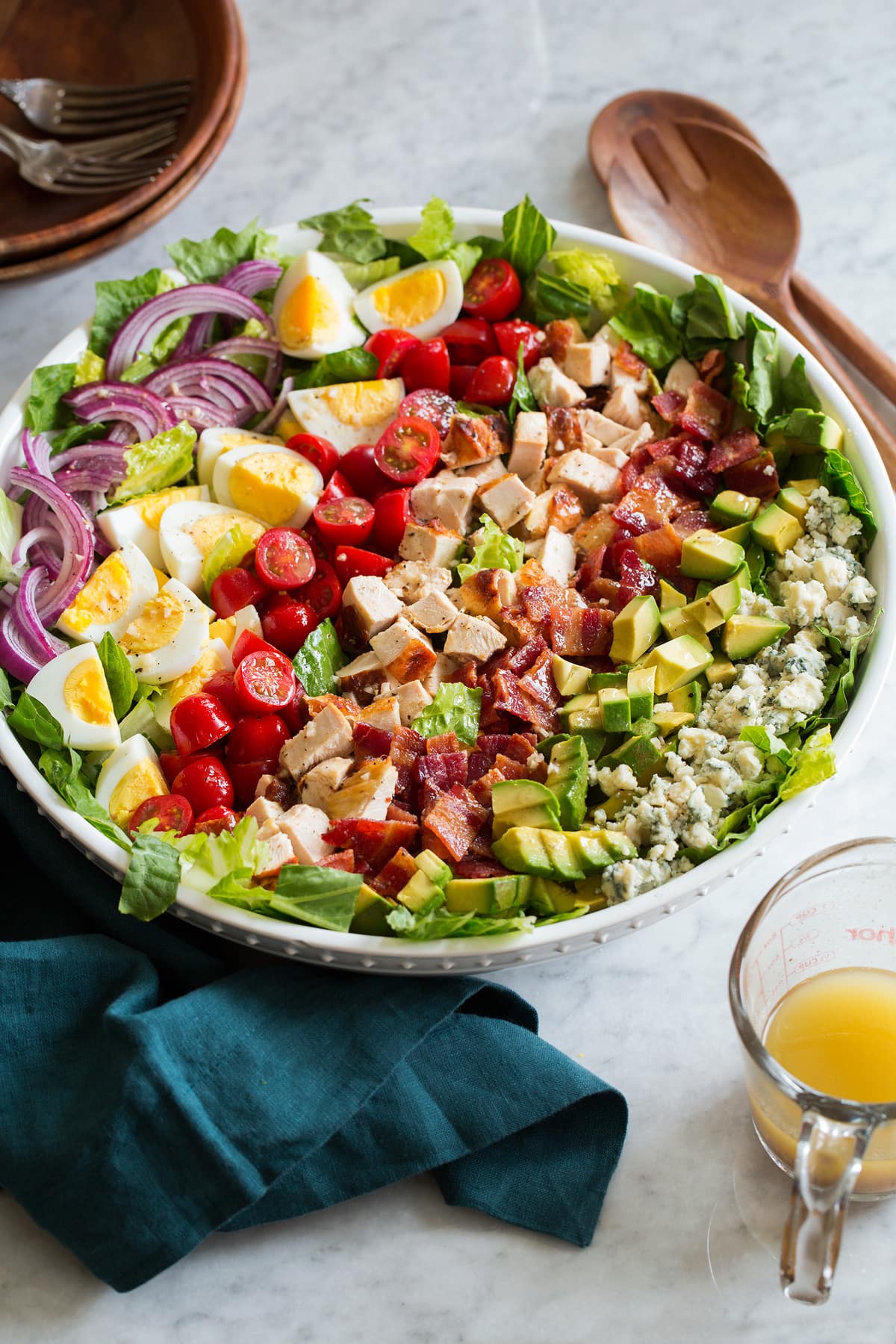 Cobb salad shown from the side on a marble surface.