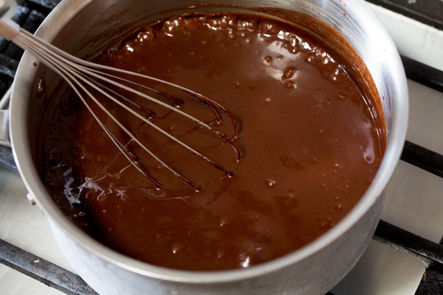 Simmering ice cream fudge sauce in saucepan.