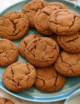 Molasses cookies layered on a blue plate.