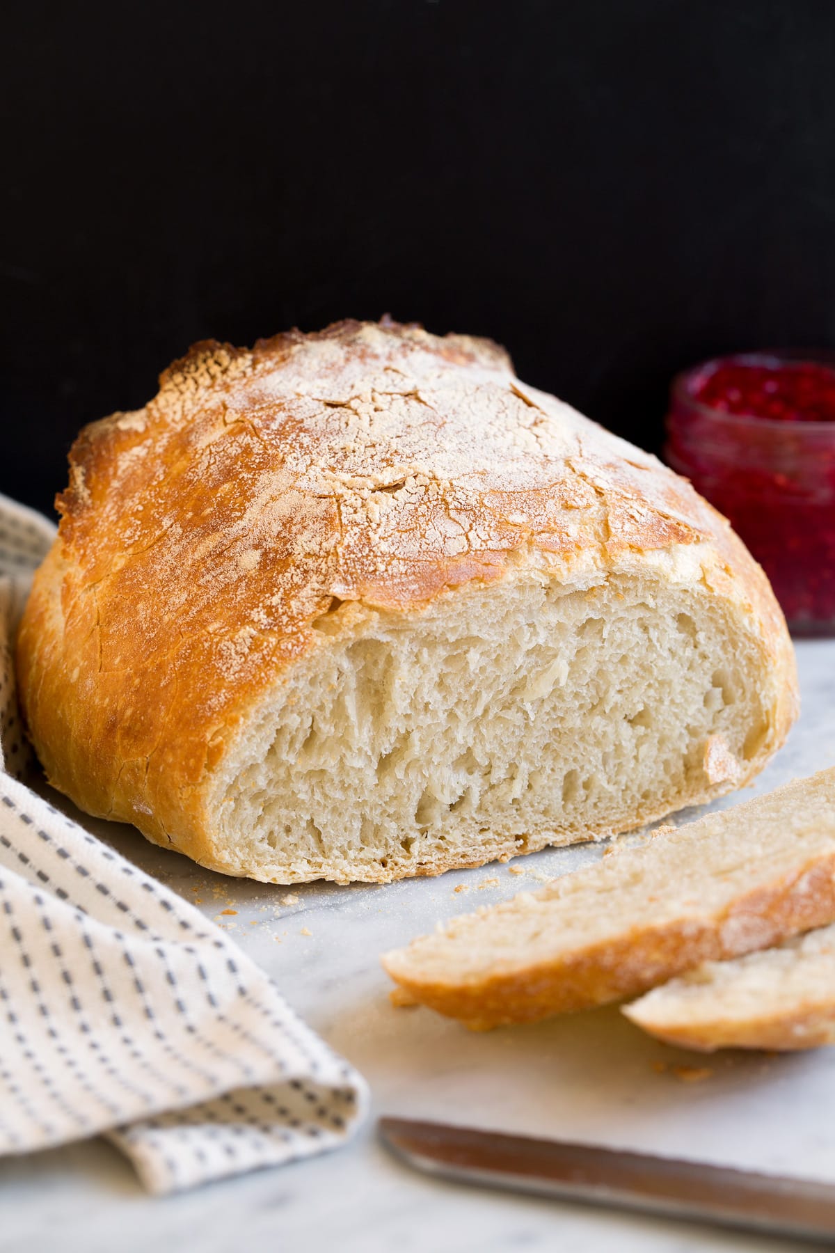 No knead bread shown with a few pieces sliced of to show interior texture.
