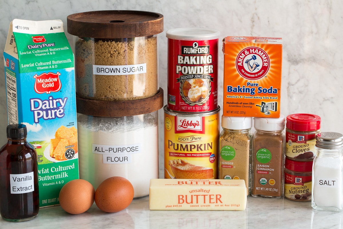 Image of ingredients used to make pumpkin pancakes. Shows flour, brown sugar, salt, baking powder, baking soda, spices, butter, buttermilk, eggs and vanilla.
