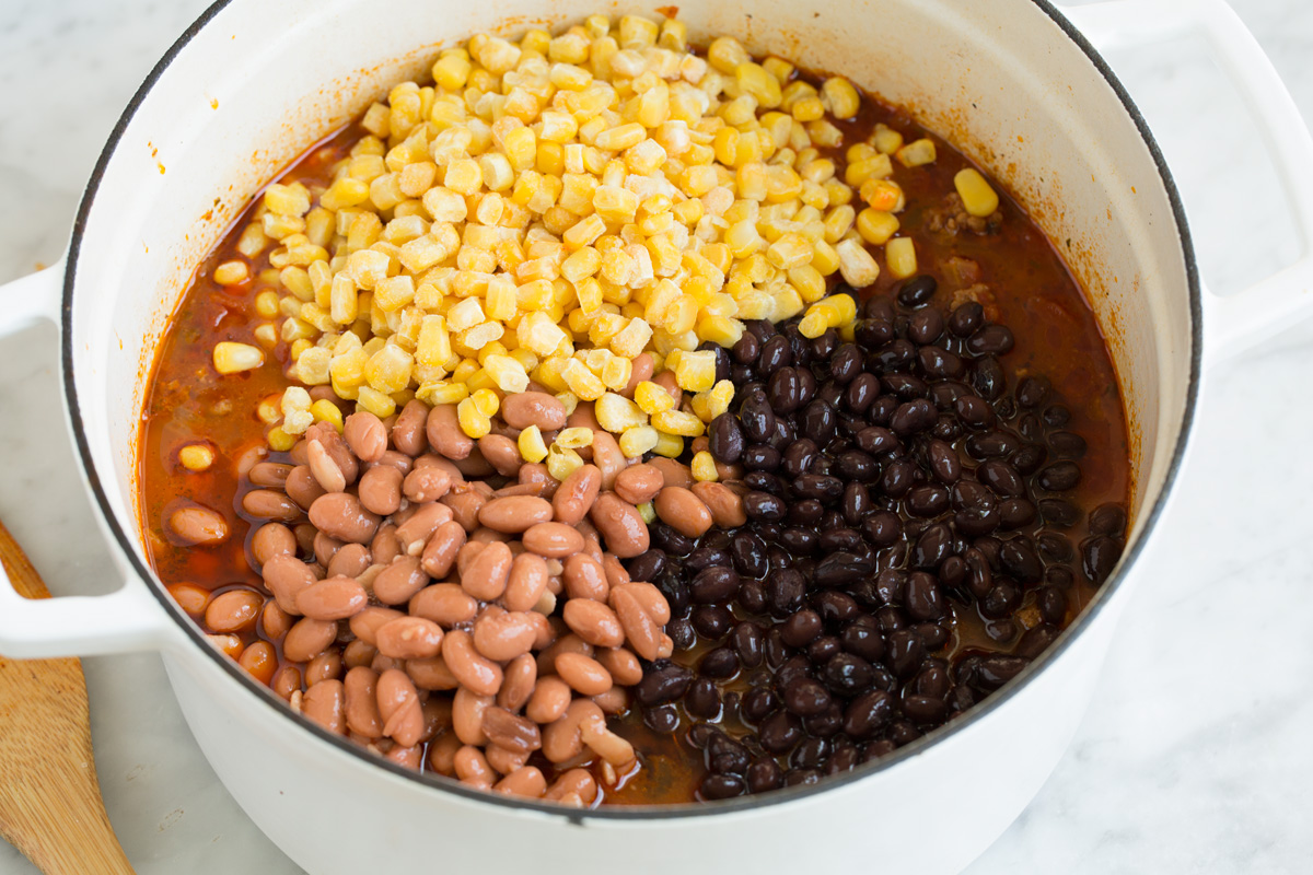 Adding beans and corn to taco soup.